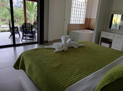 ein Schlafzimmer mit einem Bett und einem Handtuch darauf in der Unterkunft Hostería Las Palmas in Tena