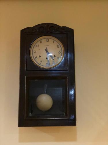 a clock on a wall with a ball on it at Hotel Villa de Minas in Monte Sião