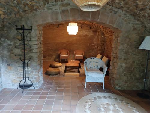 een kamer met stoelen en een tafel in een stenen muur bij Casa Peratallada in Peratallada