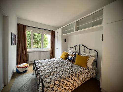 une chambre avec un lit avec des oreillers jaunes et une fenêtre dans l'établissement La Suite 108, à Rouen