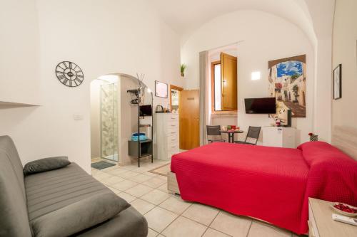 uma sala de estar com uma cama vermelha e um sofá em B&B Martini Home 11 em Altamura