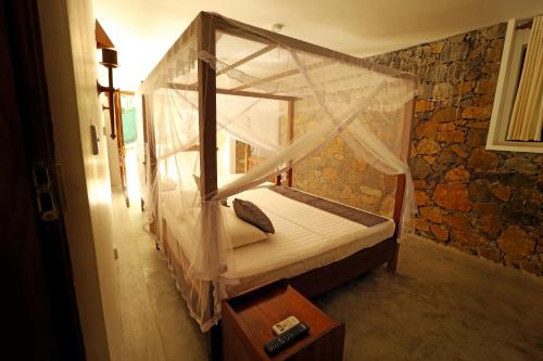 a bedroom with a canopy bed in a room at Beach Grove Villas in Unawatuna