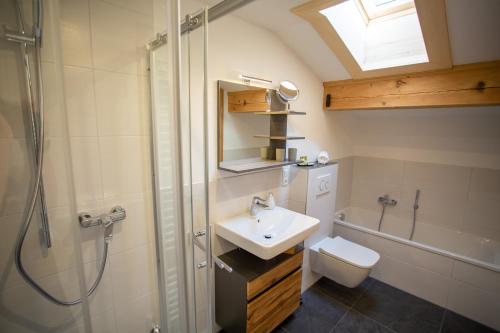 a bathroom with a sink and a shower and a toilet at Ramslerhof - Chiemgau Karte in Inzell