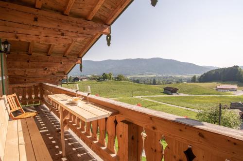 a wooden deck with a table and a bench on it at Ramslerhof - Chiemgau Karte in Inzell