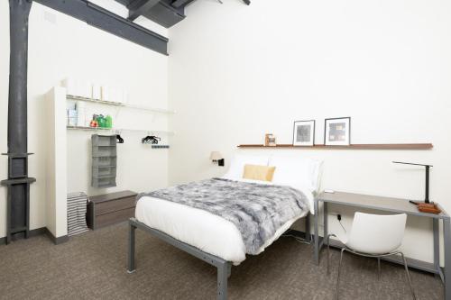 ミルウォーキーにあるCream City 2BR Apt - Just 3 Blocks to Fiserv with Gym and Parkingのベッドと机とテーブルのある寝室