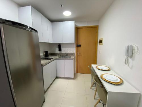 a small kitchen with a table and a refrigerator at O melhor apartamento no shopping in Águas Claras