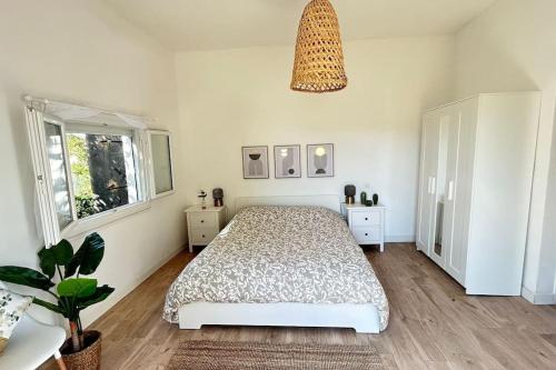 um quarto com uma cama e um vaso de plantas em Maison, 2chambres, jardin, parking, central,6pers em Montpellier
