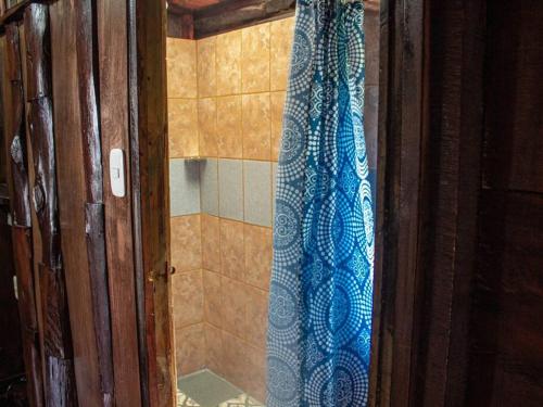 a shower with a blue shower curtain in a bathroom at La Cabaña - Parque Eólico in Santa Ana