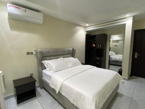 una camera con letto bianco e condizionatore d'aria di Emmaag Hotel, Ibadan a Ibadan