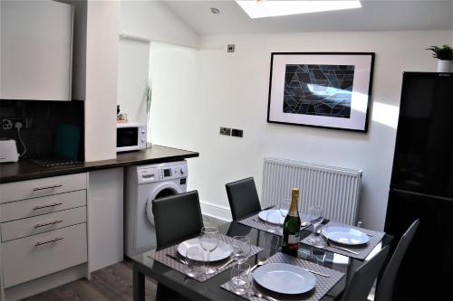 een keuken met een eettafel en een fles wijn bij Victoria 4 bedroom Serviced House Short Lets - Near Northampton Gen Hosp & Town Centre in Northampton