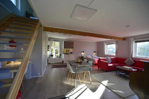 ein Wohnzimmer mit einem roten Sofa und einer Treppe in der Unterkunft Guesthouse in Manger, Radøy Island in Kollstad