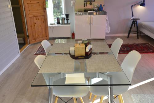 a dining room with a glass table and white chairs at Guesthouse in Manger, Radøy Island in Kollstad
