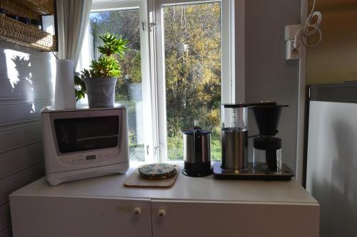 a microwave sitting on top of a kitchen counter with a window at Guesthouse in Manger, Radøy Island in Kollstad