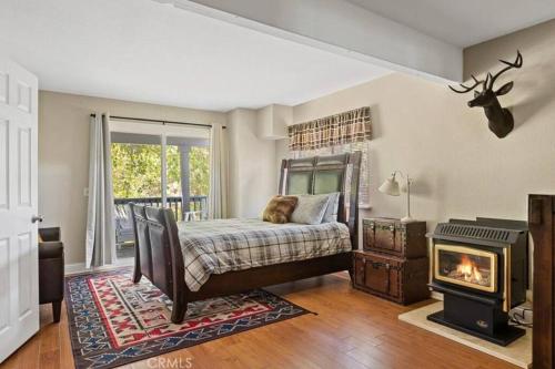 1 dormitorio con 1 cama y chimenea en Charming Getaway Cabin, en Lake Arrowhead