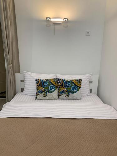 Una cama con sábanas blancas y almohadas. en Center Lviv Avenue 23, en Leópolis