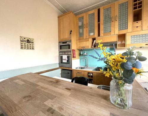 una cocina con un jarrón de flores sobre una mesa en Lovely Victorian Apartment in Clifton Village, en Bristol