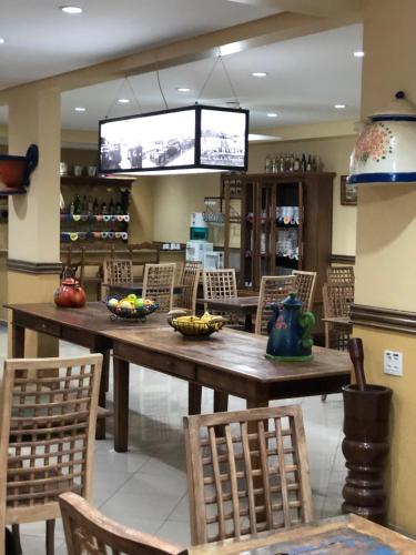 a dining room with a large wooden table and chairs at Hotel Villa de Minas in Monte Sião