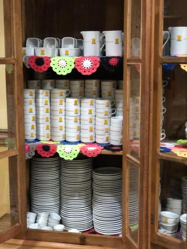 a cabinet filled with plates and cups and dishes at Hotel Villa de Minas in Monte Sião