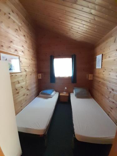 a room with two beds in a wooden cabin at L'Occitana in Mauroux