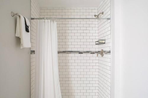 baño con ducha con cortina blanca en Flexhome Marquette Economy 2BR Apt MP5 - READ INFO en Milwaukee