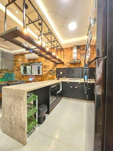 a large kitchen with black cabinets and a counter at Alto Padrón. Para exigentes in Ciudad del Este