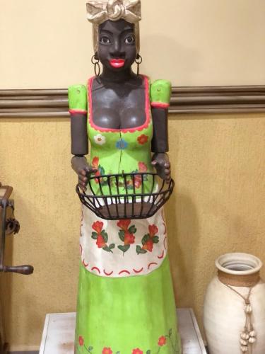 a statue of a woman holding a basket on a table at Hotel Villa de Minas in Monte Sião