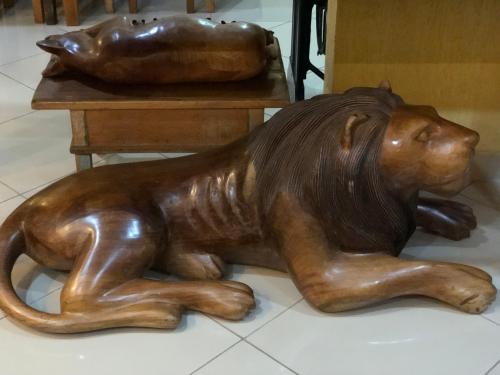 a wooden dog laying on the floor next to a table at Hotel Villa de Minas in Monte Sião