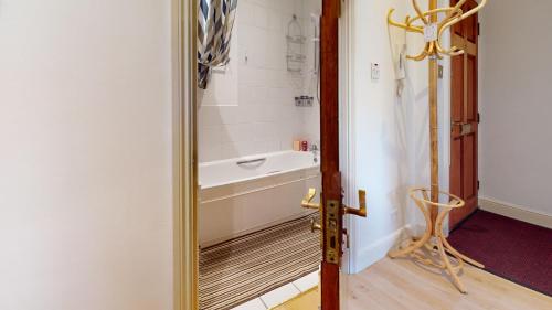 a bathroom with a bath tub and a mirror at The Cosy Bay Near Tower Bridge in London