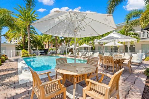 uma mesa com um guarda-sol ao lado de uma piscina em Hotel Cabana Clearwater Beach em Clearwater Beach