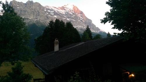 a building with a church in front of a mountain at MOM - Alpine Boutique Apartments, Grindelwald gletscher, Eiger View Terrace Studio in Grindelwald