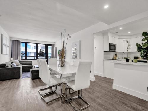 a white kitchen and living room with a table and chairs at Gorgeous Miami Beach Condo Beach Service 1614 in Miami Beach