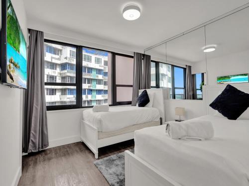 a bedroom with two beds and a large window at Gorgeous Miami Beach Condo Beach Service 1614 in Miami Beach