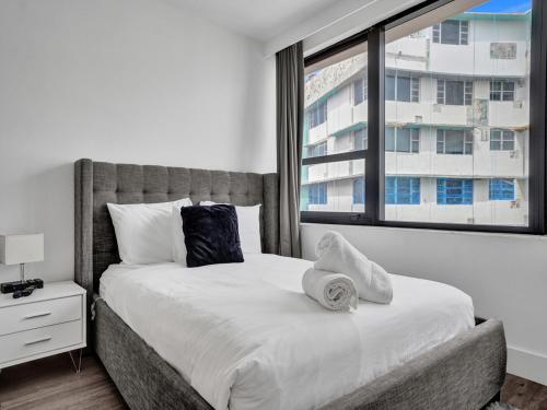 a bedroom with a large bed with a window at Gorgeous Miami Beach Condo Beach Service 1614 in Miami Beach