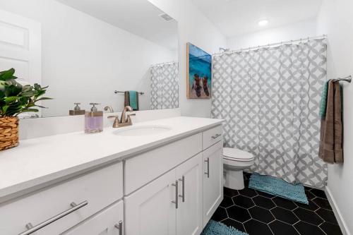 een witte badkamer met een wastafel en een toilet bij Modern Elegance - Just 10 Mins to U of A in Fayetteville