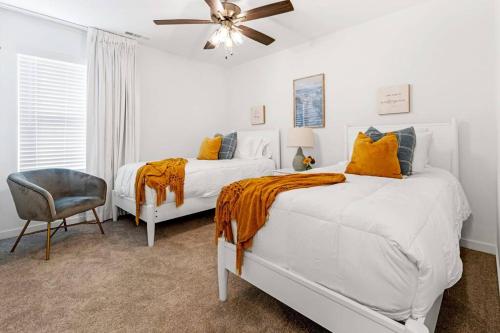 een slaapkamer met 2 bedden en een plafondventilator bij Modern Elegance - Just 10 Mins to U of A in Fayetteville