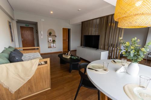 un soggiorno con tavolo bianco e divano di Ushuaia Homes Downtown Apartments a Ushuaia