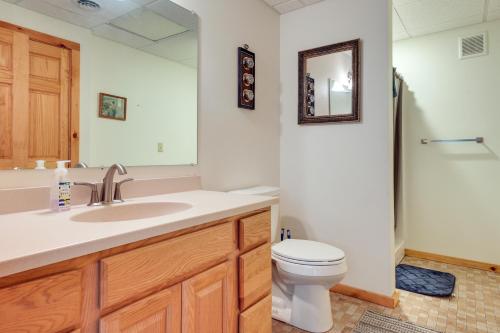 een badkamer met een wastafel, een toilet en een spiegel bij Monico Lakefront Home with Boat Dock and Fire Pit! 