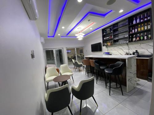 un bar con sedie bianche e bancone bar di Emmaag Hotel, Ibadan a Ibadan