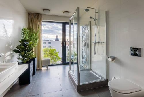 a bathroom with a shower and a toilet and a window at 5BR+2Bath Old Town Industrial Penthouse, A/C in Prague