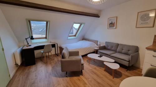 a bedroom with a bed and a couch and a table at Studio Babylone - Parking & Wifi in Chartres