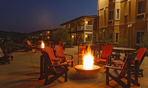 a group of chairs sitting around a fire pit at night at Berlin Resort in Millersburg
