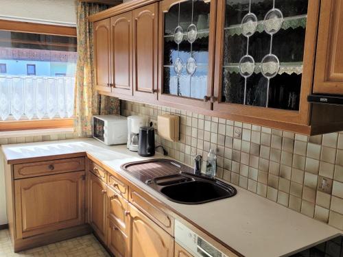 eine Küche mit Holzschränken und einem Waschbecken in der Unterkunft Apartment Buntweg-1 by Interhome in Zams