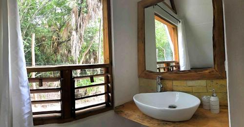 a bathroom with a sink and a mirror and a window at Kin Resort Lodge in Maya Beach