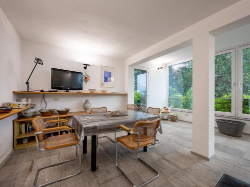 a dining room with a table and chairs and a tv at Holiday Home Il Roccolo by Interhome in Pettenasco