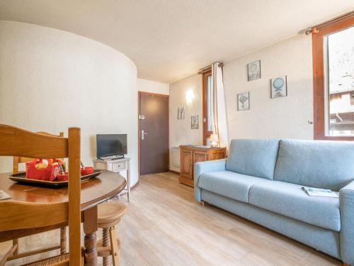 un salon avec un canapé bleu et une table dans l'établissement Apartment Le Mummery-4 by Interhome, à Chamonix-Mont-Blanc