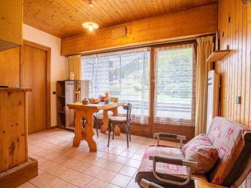 - un salon avec une table, un canapé et une fenêtre dans l'établissement Apartment Clos du Savoy-10 by Interhome, à Chamonix-Mont-Blanc