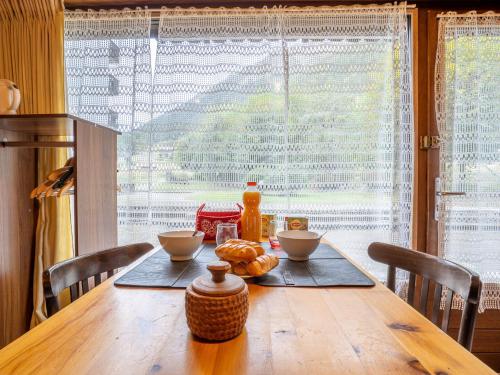 une table en bois avec de la nourriture devant une fenêtre dans l'établissement Apartment Clos du Savoy-10 by Interhome, à Chamonix-Mont-Blanc