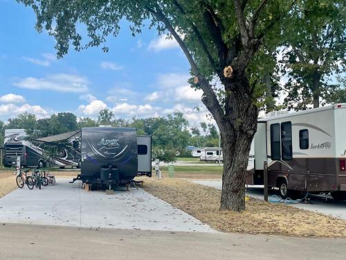 a group of rvs parked next to a tree at Elkhorn Creek RV Park in Frankfort