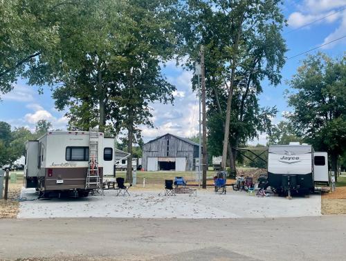 two trailers are parked in front of a barn at Elkhorn Creek RV Park in Frankfort