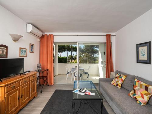 ein Wohnzimmer mit einem Sofa und einem TV in der Unterkunft Apartment Jardin de miraflores by Interhome in Mijas Costa